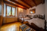 Charming rustic bedroom with wooden beams, twin beds, and a view of the countryside.