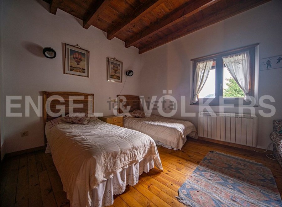 Charming bedroom with twin beds, wooden floors, and a rustic feel.