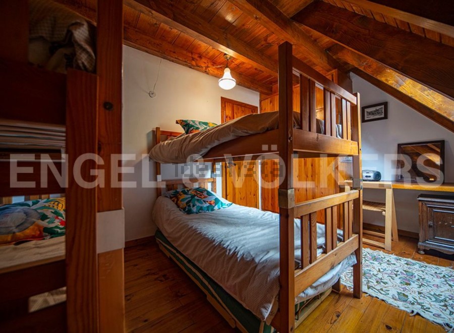 Cozy attic bedroom with wooden bunk beds, perfect for a family getaway.