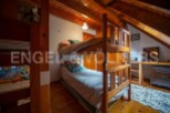 Cozy attic bedroom with wooden bunk beds, perfect for a family getaway.