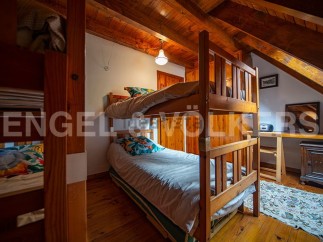 Cozy attic bedroom with wooden bunk beds, perfect for a family getaway.