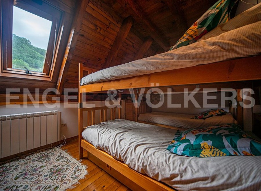 Cozy attic bedroom with wooden bunk beds, perfect for kids or guests.
