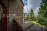 This stunning property boasts a rustic stone exterior and a charming wooden balcony, offering breathtaking mountain views.