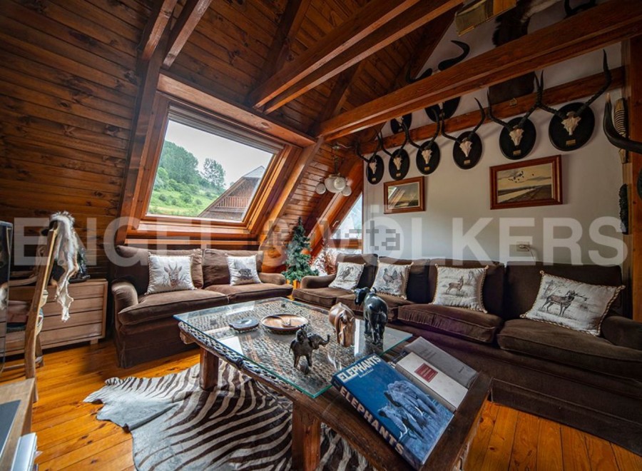 This stunning chalet boasts a spacious open-plan living area with a cozy, rustic feel.