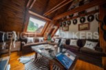 This stunning chalet boasts a spacious open-plan living area with a cozy, rustic feel.