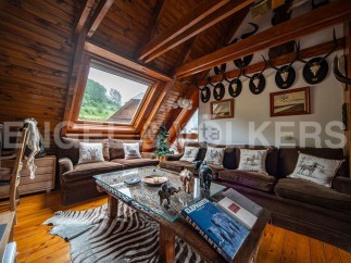 This stunning chalet boasts a spacious open-plan living area with a cozy, rustic feel.