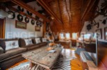 This stunning property boasts a unique, wood-beamed interior with a cozy living area featuring a large sofa and coffee table.