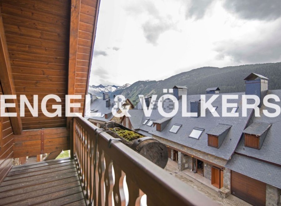 Mountain view balcony with wooden railings and flooring.