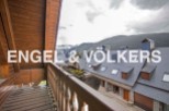 Mountain view balcony with wooden railings and flooring.