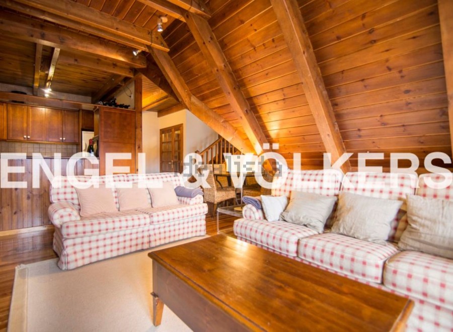 Cozy A-frame chalet with exposed wooden beams and a spacious living area.