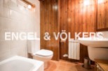 Charming bathroom with wooden wall paneling, white tiled floors, and modern fixtures.