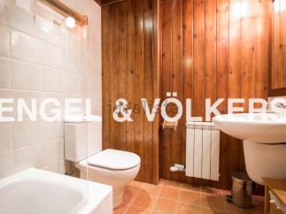 Charming bathroom with wooden wall paneling, white tiled floors, and modern fixtures.