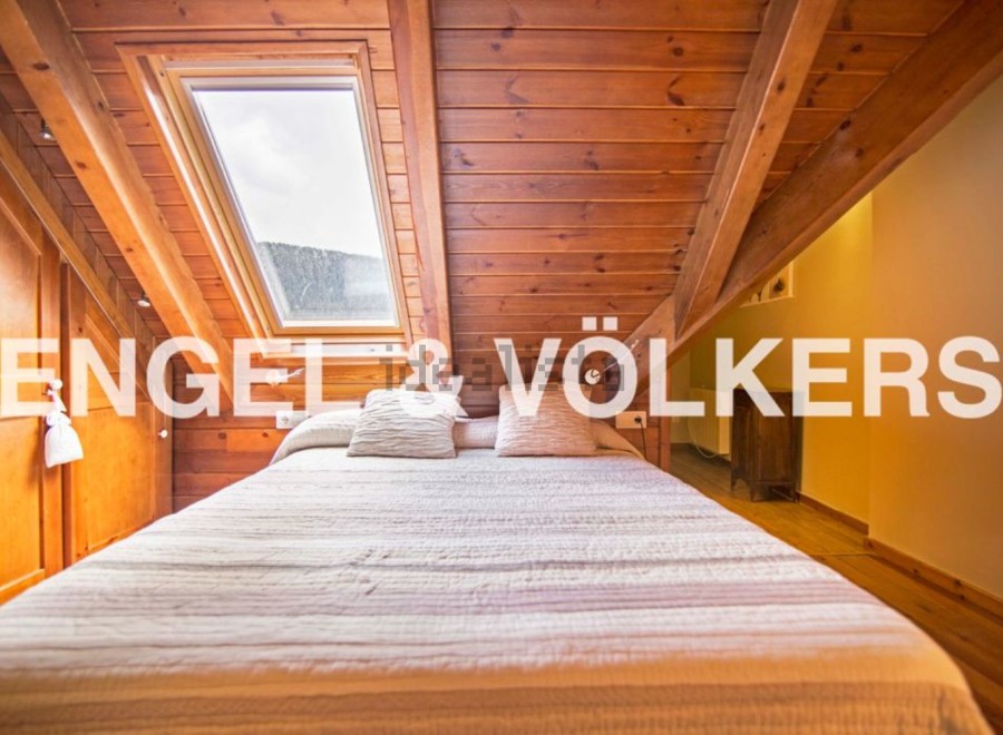 Cosy attic bedroom with wooden beams and skylights.