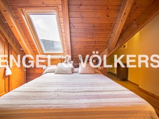 Cosy attic bedroom with wooden beams and skylights.