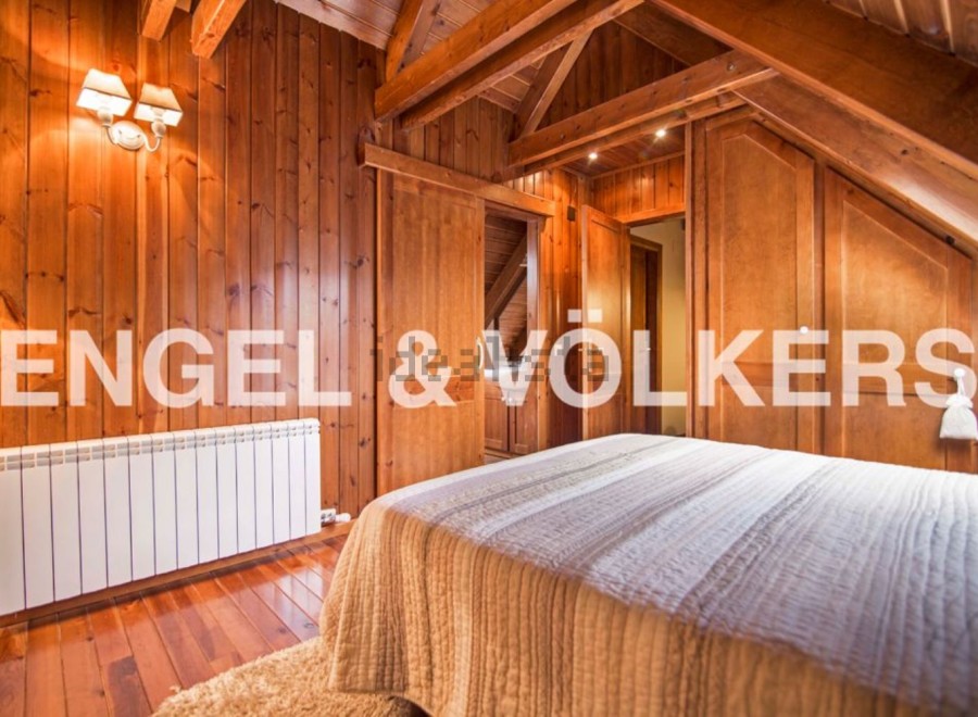 Cozy wooden bedroom with built-in wardrobes and a warm atmosphere.