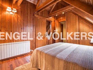 Cozy wooden bedroom with built-in wardrobes and a warm atmosphere.