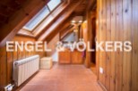 Charming attic bathroom with wooden beams, skylights, and terracotta tile flooring.