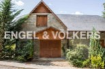 This charming stone house boasts a unique wooden facade and a spacious double door entrance.