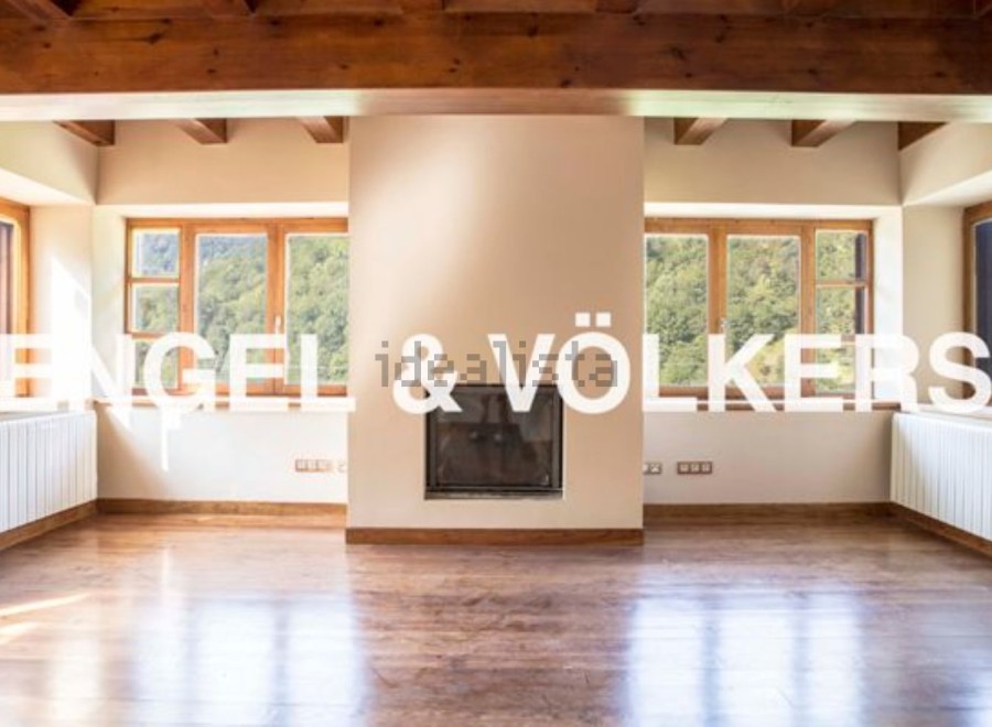Spectacular mountain views fill this open-concept living space, featuring hardwood floors and a cozy fireplace.