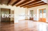 Spacious living area with hardwood floors and exposed wooden beams.