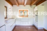 Modern kitchen with white cabinets and wooden beams.