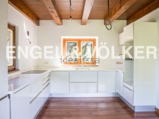 Modern kitchen with white cabinets and wooden beams.