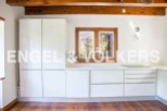 Modern kitchen with white cabinets and wooden beams.