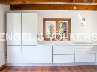 Modern kitchen with white cabinets and wooden beams.