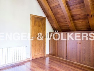 Charming attic room with wooden beams and built-in wardrobes.