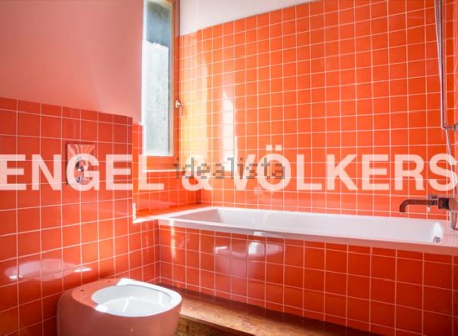 This stylish bathroom boasts vibrant orange tiles, creating a retro-chic atmosphere.