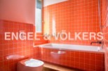 This stylish bathroom boasts vibrant orange tiles, creating a retro-chic atmosphere.
