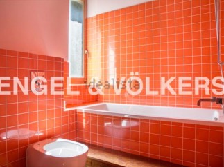 This stylish bathroom boasts vibrant orange tiles, creating a retro-chic atmosphere.