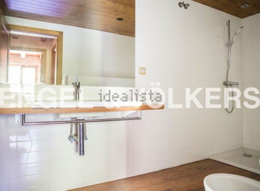 Modern bathroom with sleek wooden vanity and built-in shower.