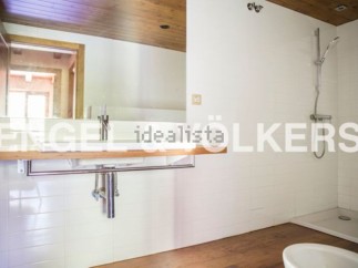 Modern bathroom with sleek wooden vanity and built-in shower.