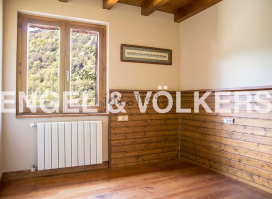 Cozy room with wooden wall paneling and large window offering scenic views.