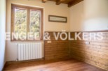 Cozy room with wooden wall paneling and large window offering scenic views.