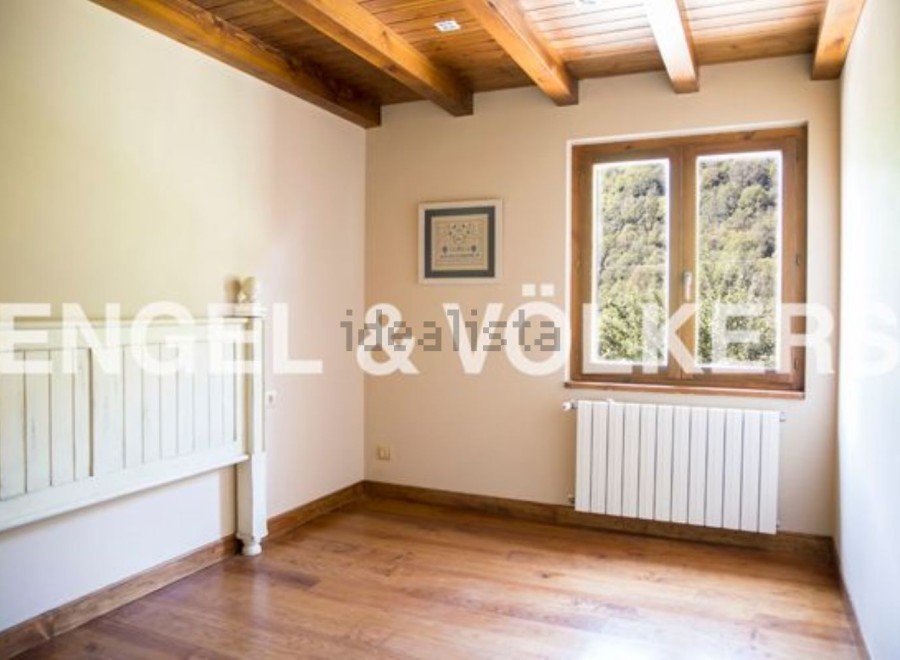 Charming bedroom with wooden beams and hardwood floors.