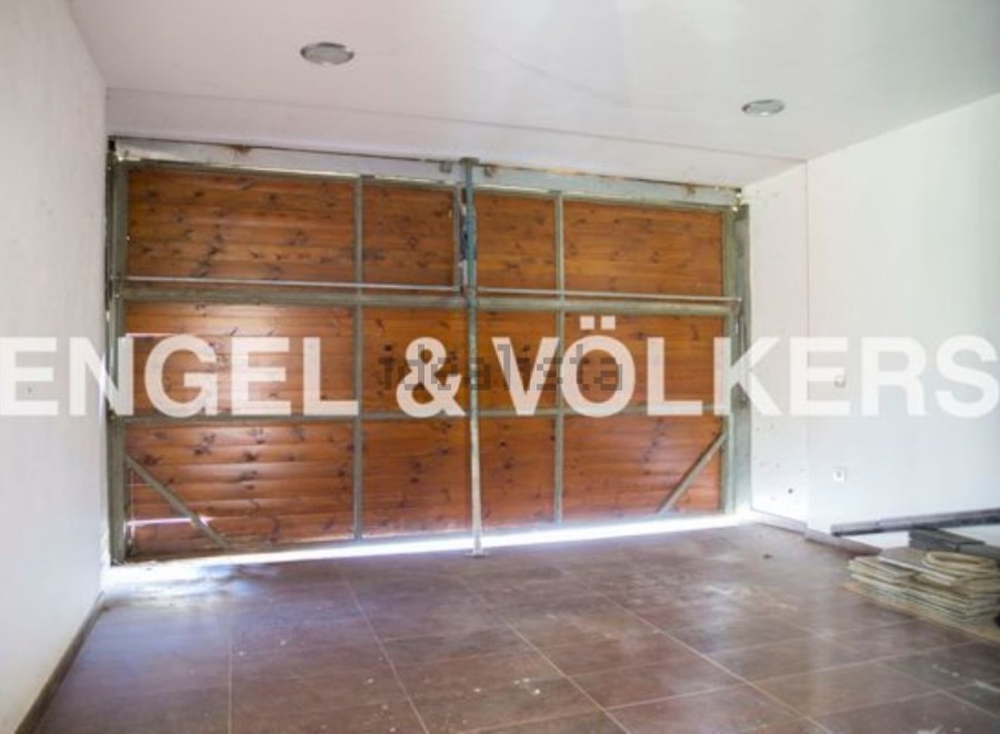Spacious garage with wooden doors, offering ample storage space.