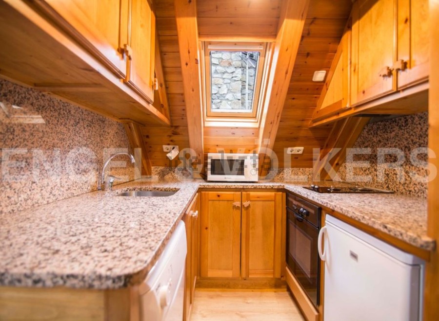 Cozy chalet kitchen with granite countertops and wooden cabinetry.