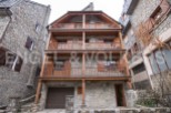 Charming stone house with wooden balconies and garage.
