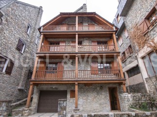 Charming stone house with wooden balconies and garage.