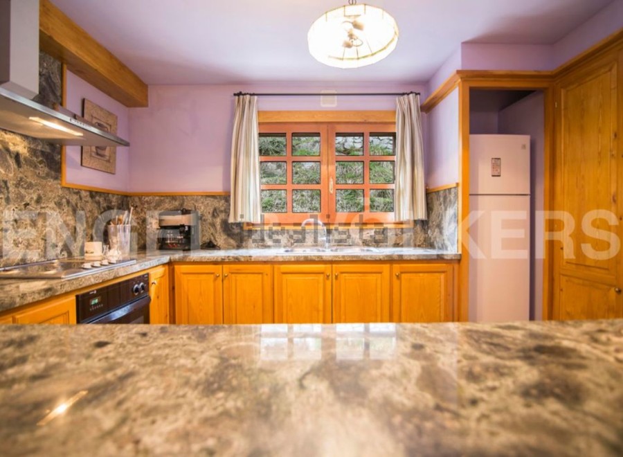 This stunning kitchen boasts beautiful granite countertops and wooden cabinetry, creating a warm and inviting atmosphere.