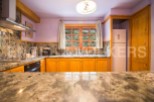 This stunning kitchen boasts beautiful granite countertops and wooden cabinetry, creating a warm and inviting atmosphere.