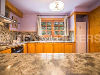This stunning kitchen boasts beautiful granite countertops and wooden cabinetry, creating a warm and inviting atmosphere.