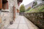 This charming stone house boasts a private patio perfect for outdoor relaxation, nestled in a picturesque mountain setting.