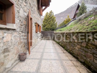 This charming stone house boasts a private patio perfect for outdoor relaxation, nestled in a picturesque mountain setting.