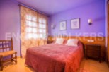 Charming bedroom with double bed, floral curtains, and wooden nightstand.