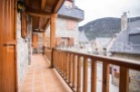 This stunning property boasts a charming wooden balcony overlooking a picturesque mountain village.