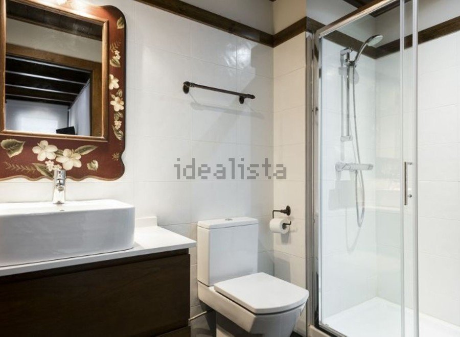 Charming bathroom with a vintage-style mirror and modern fixtures.