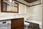 This stunning bathroom boasts a modern design with sleek wooden cabinetry and a spacious bathtub.